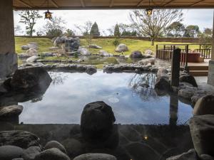 a pool of water with rocks in a yard at La Vista Kirishima Hills in Kirishima