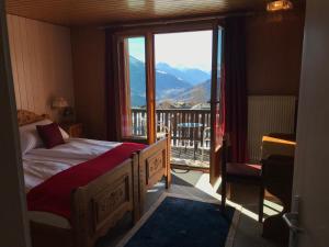a bedroom with a bed and a balcony with a view at Hotel Wannenhorn in Bellwald
