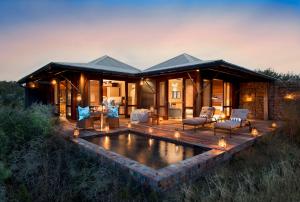 a house with a pond in front of it at Kwandwe Private Game Reserve - Ecca Lodge in Grahamstown