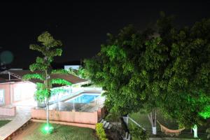 a house with a swimming pool at night at Pousada Morro dos Ventos in São João del Rei