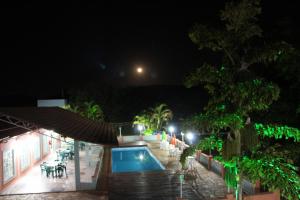 a night view of a swimming pool at a resort at Pousada Morro dos Ventos in São João del Rei