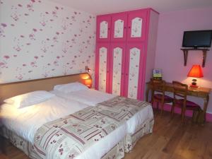 1 dormitorio con 1 cama, escritorio y TV en Hotel Le Bellevue, en Saint-Hippolyte
