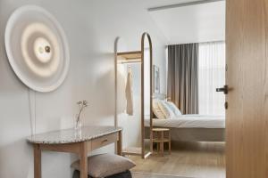a bedroom with a bed and a table and a mirror at Original Sokos Hotel Tripla Helsinki in Helsinki