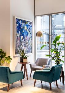 a living room with two chairs and a painting at The Gate London City in London