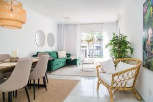 ein Wohnzimmer mit einem grünen Sofa und einem Tisch in der Unterkunft Stylish Penthouse 2 pools & next to beach - RDR204 in Marbella