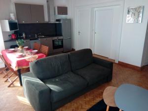 ein Wohnzimmer mit einem Sofa und einem Tisch in der Unterkunft Passionné de la plage in Dunkerque