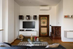 een woonkamer met een bank en een tv bij Appartamento panoramico San Martino 12 in Siena