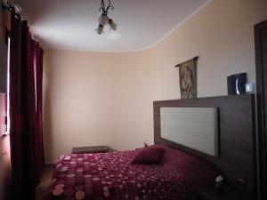 um quarto com uma cama com um cobertor vermelho em Agriturismo Il Drago em Piazza Armerina