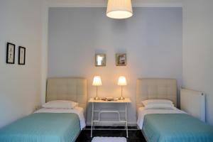 a room with two beds and a table with lamps at Anna's Family Home in Leonidion