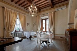 a dining room with two tables and a chandelier at VillAmorosa in Calci