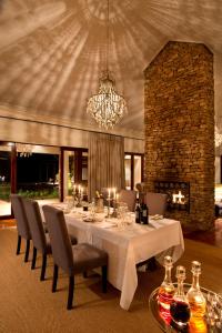 a dining room with a table with chairs and a chandelier at Kwandwe Melton Manor in Grahamstown