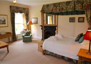 a bedroom with a large bed and a fireplace at Delphi Lodge in Leenaun