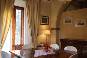 un comedor con una mesa con un bol de fruta. en VillAmorosa, en Calci