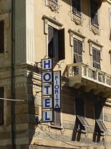 una señal para un hotel al lado de un edificio en Albergo Fiorita en Génova