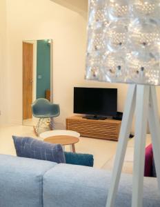 uma sala de estar com um sofá e uma televisão em Regent House deluxe 1 bedroom apartment em Harrogate
