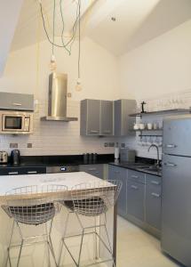 uma cozinha com armários cinzentos e um balcão branco em Regent House deluxe 1 bedroom apartment em Harrogate