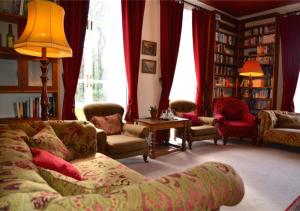 a living room with a couch and chairs and a lamp at Delphi Lodge in Leenaun