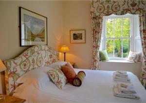 a bedroom with a white bed with a window at Delphi Lodge in Leenaun
