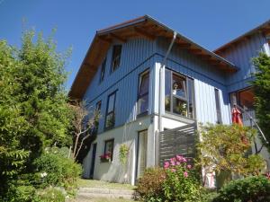 a blue house with a gambrel roof at Ferienwohnung Eisele in Buchenberg