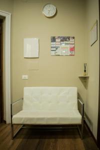 um sofá branco num quarto com um relógio na parede em Prati Comfort em Roma