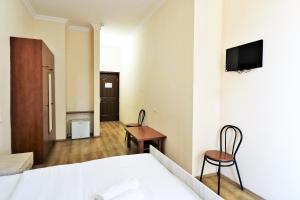 Habitación de hotel con cama y TV en la pared en Ortachala Palace en Tiflis
