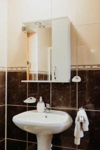 y baño con lavabo blanco y espejo. en Boutique Guesthouse „Domizil“, Valea Porumbacului, en Porumbacu de Sus
