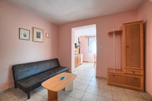 a living room with a black couch and a table at Apartment Villa Mare3 with pool, sea view and hydromassage in Banjole +17 photos
