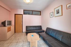 a living room with a couch and a table at Apartment Villa Mare3 with pool, sea view and hydromassage in Banjole