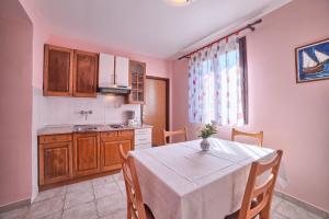 a kitchen with a table with a white table cloth at Apartment Villa Mare3 with pool, sea view and hydromassage in Banjole