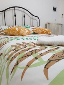 Cama con edredón y almohadas de color naranja y verde en Visconti House, en Bari