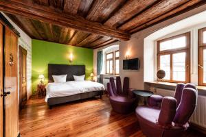 a bedroom with a bed and chairs in a room at Hotel Turmdieb in Volkach