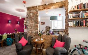 a room with chairs and a table with pink pillows at Hotel Turmdieb in Volkach