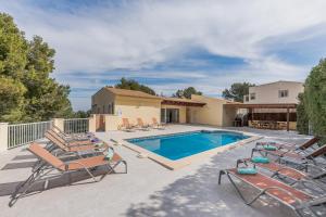 una piscina con tumbonas y una casa en YupiHome Villa Bahía de Palma - Family Only, en Cala Vinyes