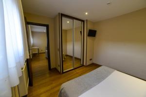 a room with a white door and a white bed at Apartamentos Turísticos Llanes in Llanes