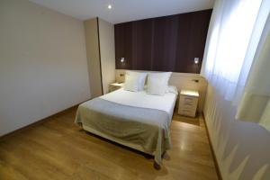 a bedroom with a bed and a dresser at Apartamentos Turísticos Llanes in Llanes
