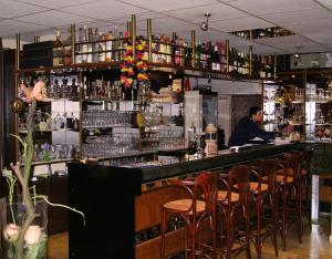 un bar avec un homme assis à un comptoir dans l'établissement Parkhotel Sonne, à Schönau im Schwarzwald