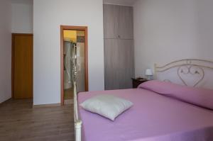 - une chambre avec un lit violet et un oreiller dans l'établissement Affittacamere Raggio di sole, à Tarente