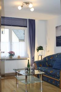 a living room with a blue couch and a glass table at Komfort Ferienhaus FEWO70 in Bremm