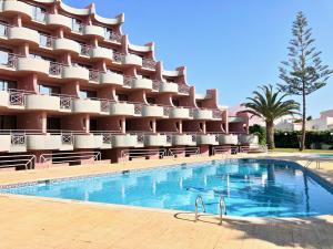 een hotel met een zwembad voor een gebouw bij Clube Oceano Apartments in Albufeira