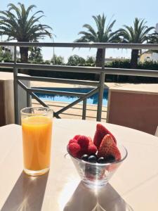 a bowl of fruit and a glass of juice on a table at Clube Oceano Apartments in Albufeira