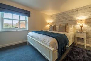 a bedroom with a large bed and a window at No33 BRACKEN BOUTIQUE COTTAGE in Brancaster
