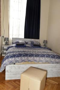 a bedroom with a large bed with a large window at Le Petit in Tbilisi City