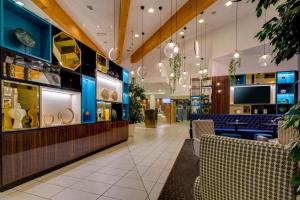a lobby of a store with chairs and a bar at Holiday Inn Bologna - Fiera by IHG in Bologna