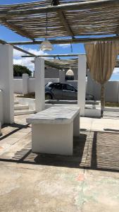 a picnic table under a pavilion with a car at Pearly Beach greek style retreat in Pearly Beach
