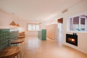 a living room with a fireplace and some stools at SubUp Hostel in Cabo de Palos