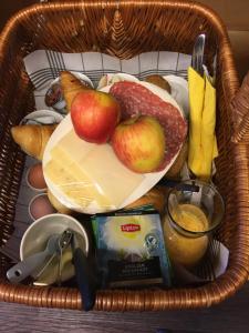 ein Korb mit Lebensmitteln mit Äpfeln, Käse und Brot in der Unterkunft Carels Kamers Texel in De Koog