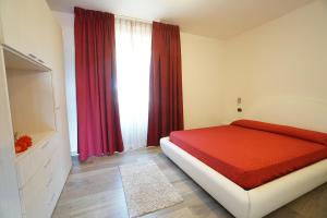 a bedroom with a bed and a window with red curtains at Cascina al Colle in Populonia