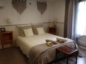 een slaapkamer met een bed met handdoeken erop bij Chambre d'Hôtes Hola in Laval
