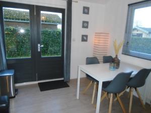 uma sala de jantar com uma mesa e cadeiras e uma porta em Rekerlanden 273 em Schoorldam