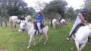 a group of people riding horses in a field at Rainforest Yasmin Hotel in Santa Fé